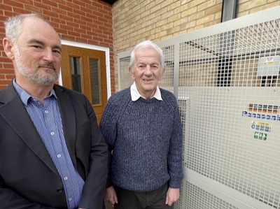 Guy Ransom, commercial director at Finn Geotherm with Cllr Gerald Kelly, West Suffolk Cabinet Member for the Environment next to an air source heat pump at one of the council's temporary accommodation sites, used to support people who are homeless.