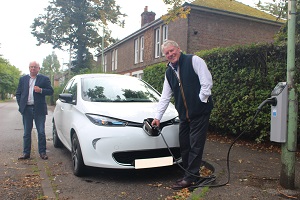 Councillor John Griffiths charging an electric car  