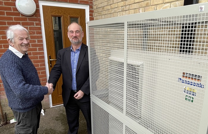 Cllr Gerald Kelly, West Suffolk Cabinet Member for the Environment and Guy Ransom, commercial director at Finn Geotherm next to an air source heat pump at one of the council's temporary accommodation sites, used to support people who are homeless.
