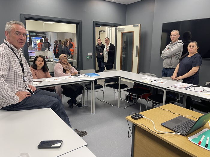 ESOL lecturer Paul Corey, and ESOL adult learners Funda Kaya, Frozan Mirzi, Michal Kamieniak and Gizelda Maria Veras De Araujo in the immersive teaching room on the ground floor of the building.