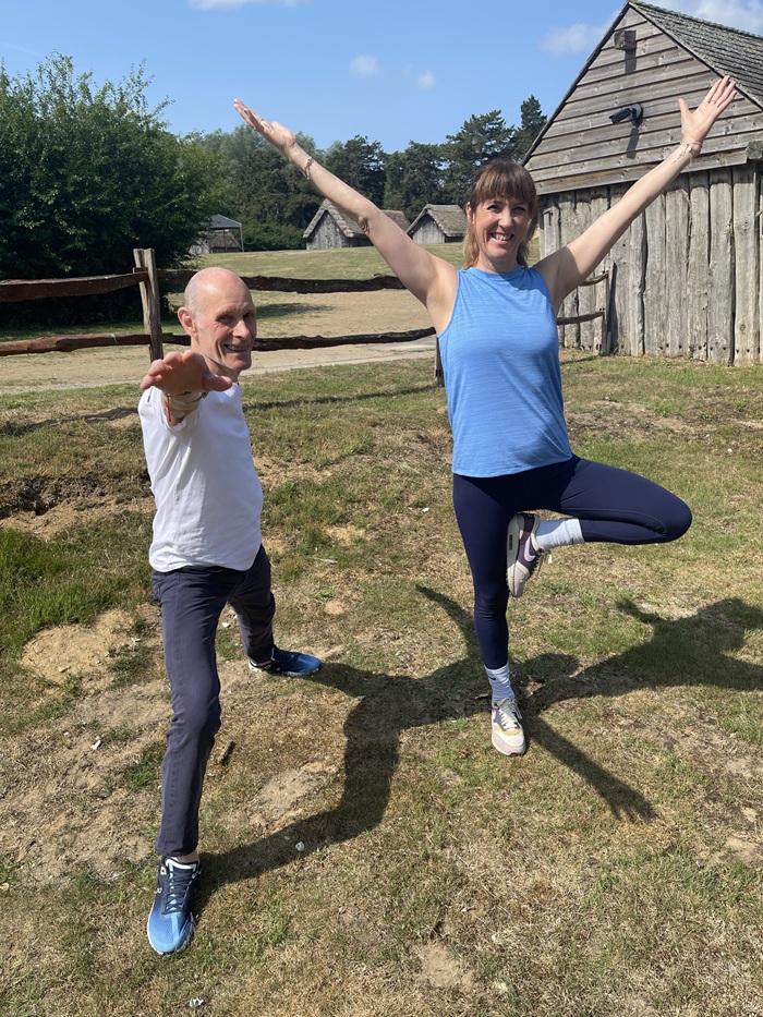 Robin Taylor performs warrior 2 while yoga instructor Tracey Clay performs the tree pose