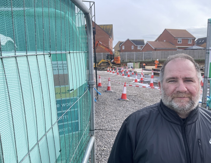 Cllr Frank Stennett at the site entrance where the new shop is being built on Marham Park