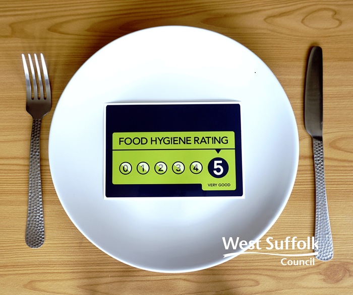 The image shows a plate, knife and fork. On the plate is the food hygiene rating label that often appears in the windows and doors of businesses. This one has a rating of 5 - very good - which is the highest rating achievable. 