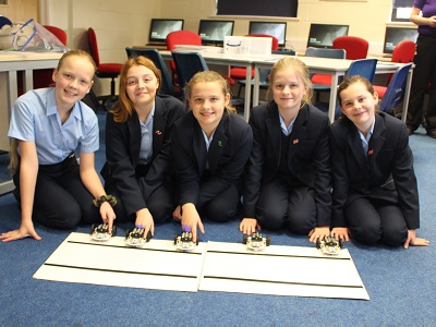 Some of the Newmarket Academy student test their robots which they have programmed to recognise and stop at a black line