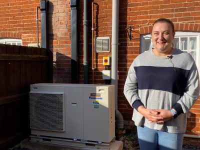 Image of smiling resident outside her house