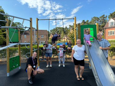 A group of adults and children at a play area. icon