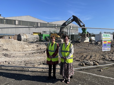 Cllr Hind and Cllr Higgins in front of construction work icon