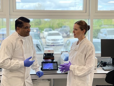 Indy, Cabinet Member for Growth at West Suffolk Council and Helen, Centre Manager at The EpiCentre, with fluorescent microscope icon