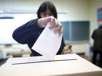 Image of person voting at a polling station icon