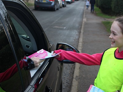 Felicity thanks a driver for not idling and hands a leaflet about the damage that idling can cause to health