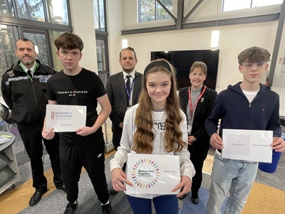 Newmarket Together - Newmarket Academy students Kieran Burke, Amy Andrew and Oscar Owen with their designs and behind them police Insp Tim Scott, Nathan Marshall from the academy and Cllr Donna Higgins